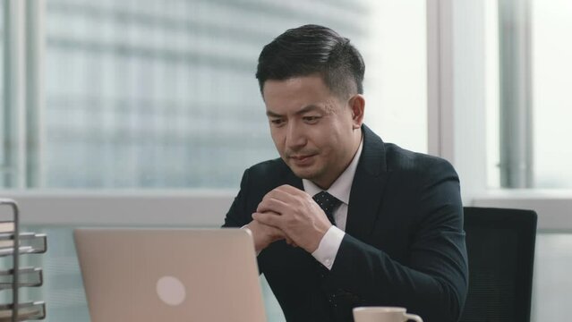 asian business man working in office using laptop computer with happy and satisfaction expression on face
