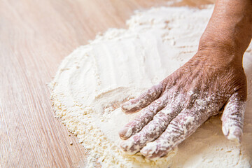 Hand flour. Hands baker with flour in kitchen. Hands woman covered in flours. Women's hands, flour and dough. Woman preparing dough for home baking. Dough on white powder covered table