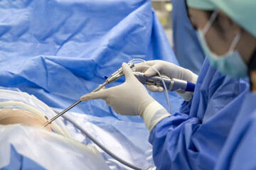 Team of doctor or surgeon and nurse in blue gown inside operating room did minimal invasive spine...