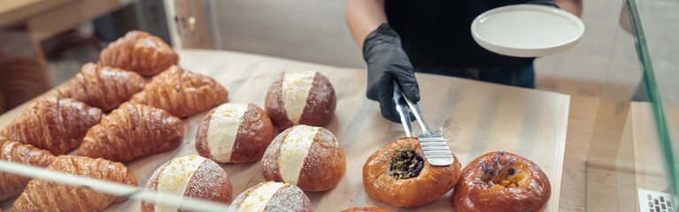 Woman in gloves putting baked goods on snowcase