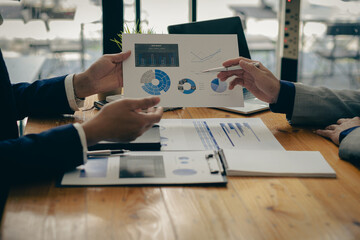 Business partners use laptops to analyze company financial budget reports, graphs and progress of work, costs and planning for the future in the office, meeting ideas.

ไทย
