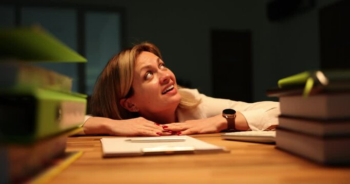 Blonde woman hides under wooden table feeling scared of lightning and thunder. Terrified female employee stays late at work in office during thunderstorm