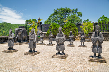 Ancient stone statues of warriors and pheasants in the courtyard of a temple at Hue in Vietnam