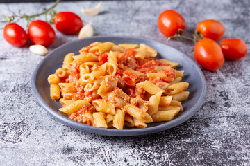 Pennette with tuna and cherry tomatoes. Typical dish of traditional Italian and Mediterranean cuisine. Healthy and balanced dish suitable for both lunch and dinner.