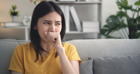 Fototapeta na wymiar Young Asian woman suffering from flu, coughing and sneezing at home