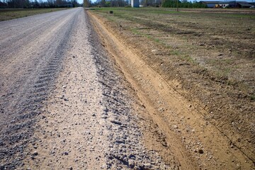 Drainage ditch along the road. View of the roadside, along which a deep ditch was dug to drain...