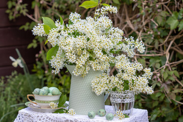 Arrangement mit Vogelkirsch-Strauß im vintage Krug und Wachteleiern