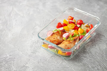 Healthy meal prep container with  chicken and vegetable salad.