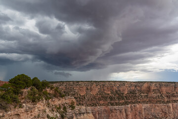 Dark clouds emerging to rain storm seen from the Bright Angel Point at South Rim of Grand Canyon National Park, Arizona, USA. Isolated summer cloudburst. Colorado River weaving through rugged terrain