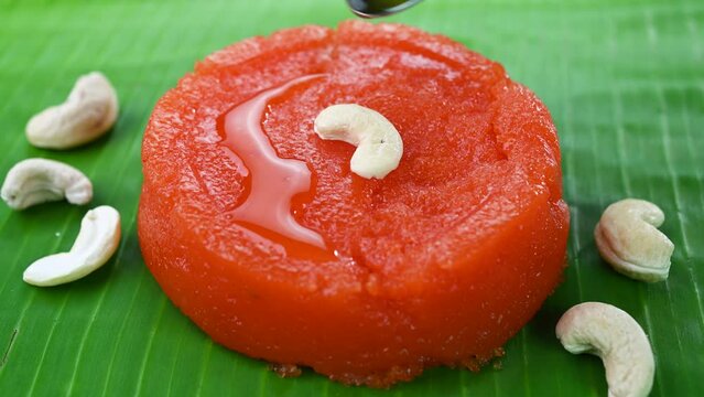 Pouring ghee on top of kesari sweet dish.