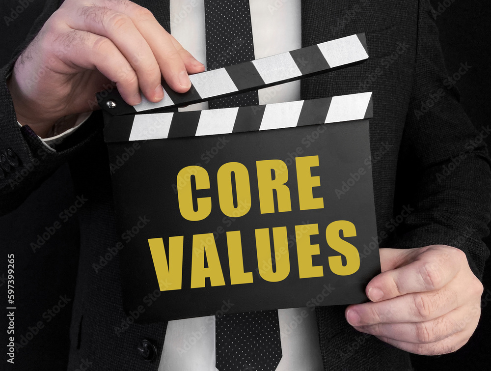 Poster a businessman holds up a ?lapperboard with text core values