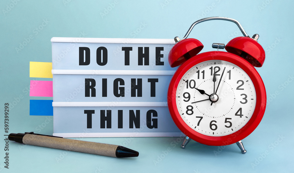 Poster text do the right thing written on the lightbox with alarm clock and colorfull stickers on blue back