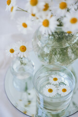 Obraz na płótnie Canvas Chamomile flowers in vases on the table. Chamomile flowers in glass vase.