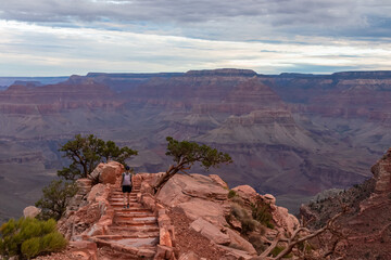 Woman with scenic view from Ooh Ahh point on South Kaibab hiking trail at South Rim, Grand Canyon National Park, Arizona, USA. Colorado River weaving through valleys and rugged terrain. O Neill Butte