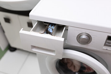 Close up of washing machine dispenser compartment container with corroded, moldy and calcified plastic for detergent and conditioner. Appliance care and cleaning. Cleansing and care. High angle view