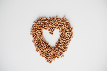 Buckwheat grain heart on white background. Healthy superfood diet