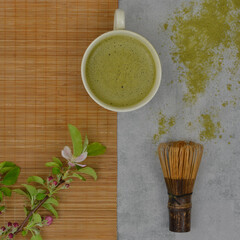 Green matcha. Japanese matcha tea tradition. Accessories, matcha powder and twig with flowers.   Top view.