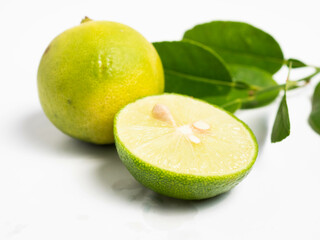 Picture of green citrus with leafs on a white isolated background