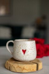 A cup of warm, warming aromatic tea, coffee, flowers nearby