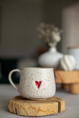 A cup of warm, warming aromatic tea, coffee, flowers nearby