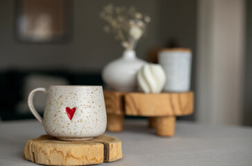 A cup of warm, warming aromatic tea, coffee, flowers nearby
