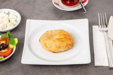 Izmir boyoz on a white porcelain plate on a stone table