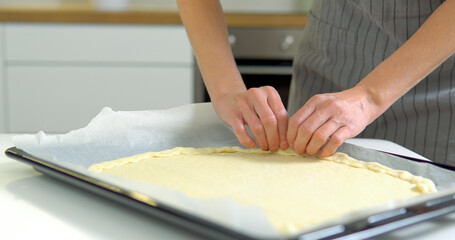 Obraz na płótnie Canvas Woman lays out the dough on a baking sheet