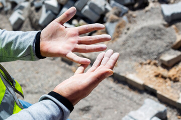 Worker's hands Close-up on a construction site, building a house from stones