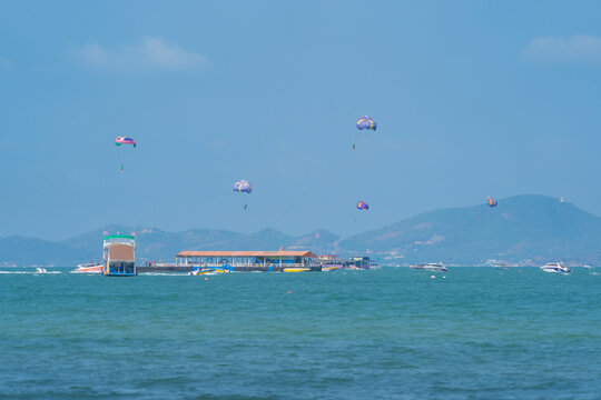 People flying in a colorful parachute or parasail together with blue sky and clouds in freedom and travel concept.