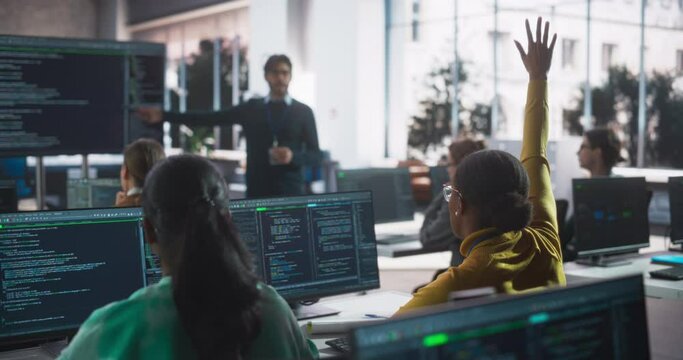 Young Professor Giving Computer Science Lecture to Diverse Multiethnic Group of Female and Male Classmates in a College Room. Student Raises Hand and Asks a Question About Artificial Intelligence