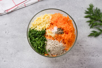 Glass bowl with ingredients for vegan cutlets, burgers: millet, carrots, seeds, herbs, garlic and...