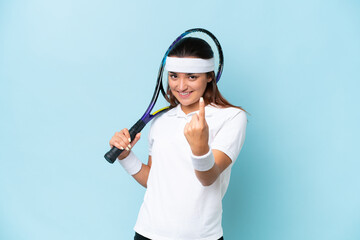 Young tennis player woman isolated on blue background doing coming gesture