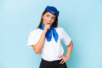 Airplane stewardess caucasian woman isolated on blue background having doubts and with confuse face expression