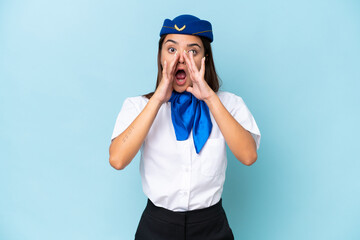 Airplane stewardess caucasian woman isolated on blue background shouting and announcing something
