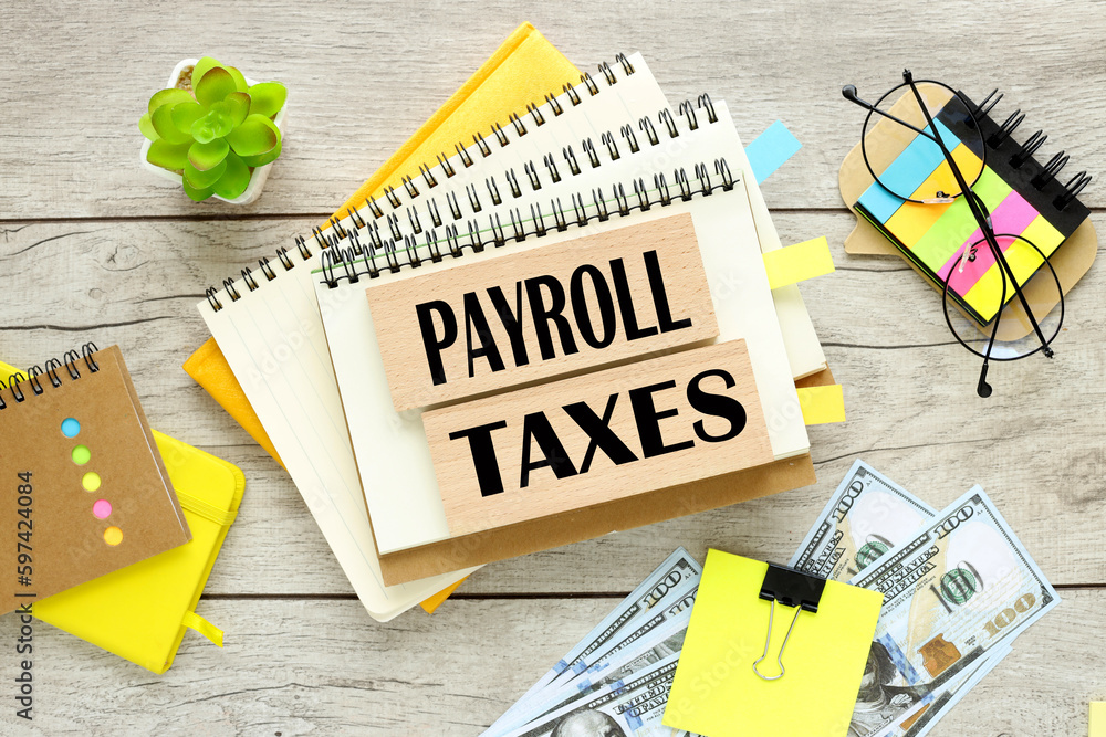 Poster payroll taxes . two wooden blocks with text on a notebook with a spring. bright stickers