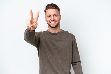 Young blonde caucasian man isolated on white background smiling and showing victory sign