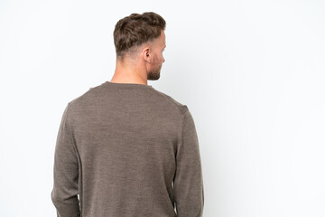 Fototapeta premium Young blonde caucasian man isolated on white background in back position and looking side