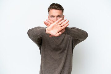 Young blonde caucasian man isolated on white background making stop gesture with her hand to stop...