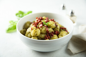 Homemade potato gnocchi with pesto and sausage 