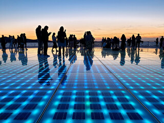 silhouette people standing on solar panel Greeting to the Sun located in Zadar, Croatia - obrazy, fototapety, plakaty