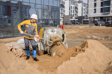 construction worker with shovel and bucket on construction site of new building