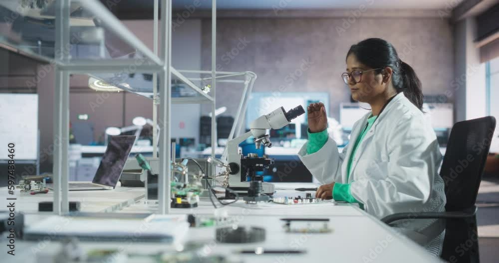Aufkleber college science classroom: diverse young south asian female experimenting with computer components, 