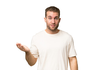 Young handsome caucasian man isolated on green chroma background making doubts gesture