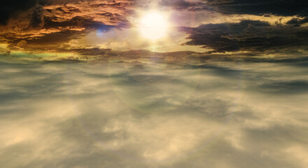 雲海を抜けた風景、夕焼け茜色の雲太陽レンズフレアとゴースト　夏・夏休み・旅行・飛行の背景イメージ