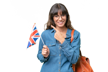 Young caucasian woman holding an United Kingdom flag over isolated background pointing to the side to present a product