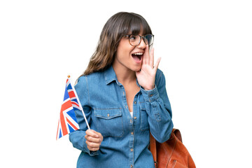 Young caucasian woman holding an United Kingdom flag over isolated background shouting with mouth...