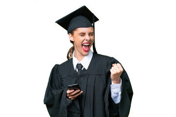 Young university graduate  caucasian woman over isolated background with phone in victory position