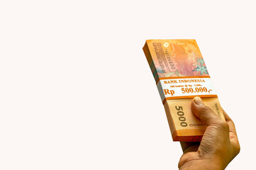 An Asian child holds Indonesian money isolated on white background