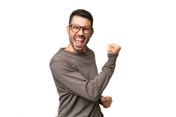 Young handsome caucasian man over isolated background celebrating a victory