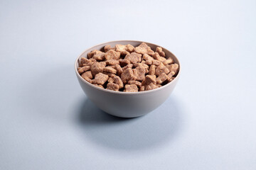 Chocolate corn snacks pads, dry breakfast in a bowl on a gray background